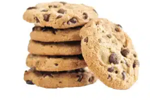 Freshly baked Nestle Toll House chocolate chip cookies on a wire rack.