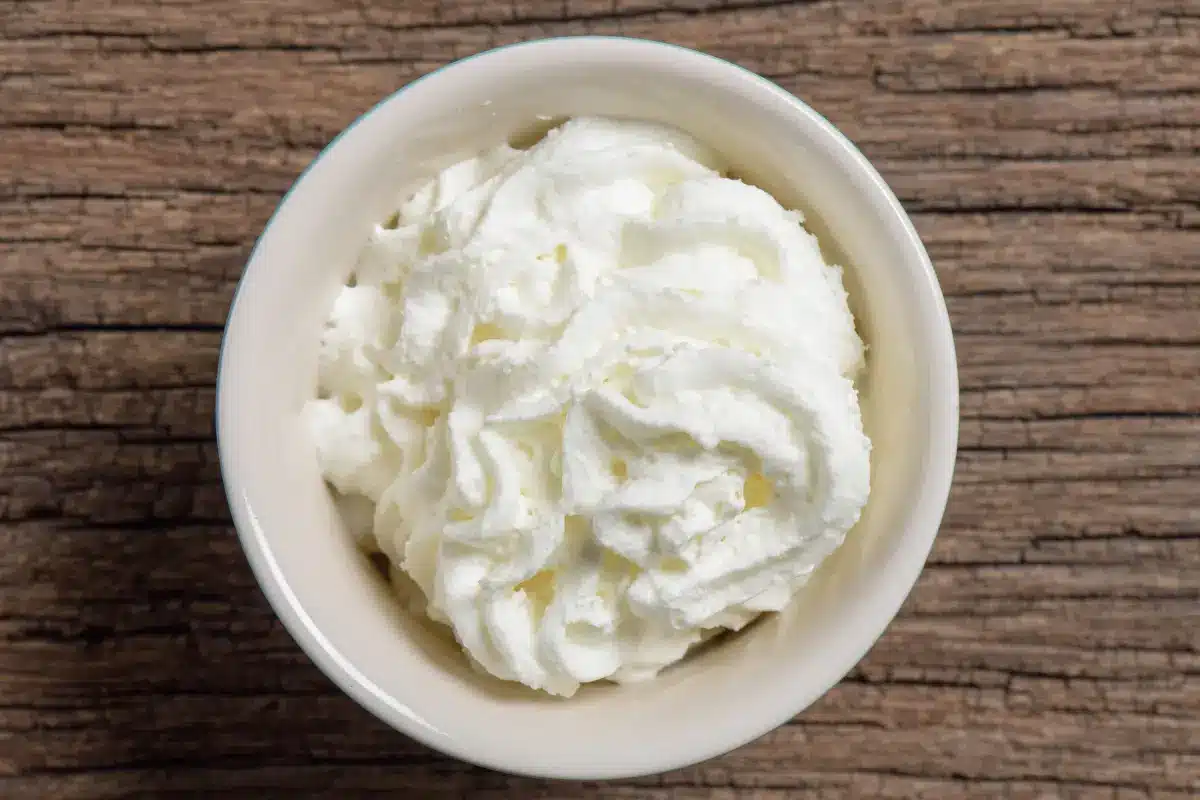 Freshly made double cream in a glass jar on a wooden table