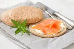 Smoked cream cheese on a wooden board with salsa and crackers.