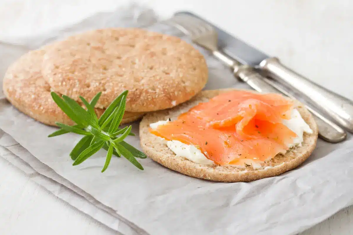 Smoked cream cheese on a wooden board with salsa and crackers.