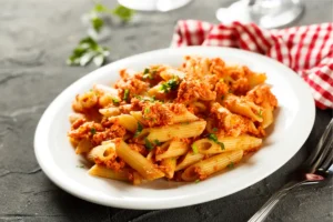 Bowl of homemade beefaroni with Parmesan and herbs.