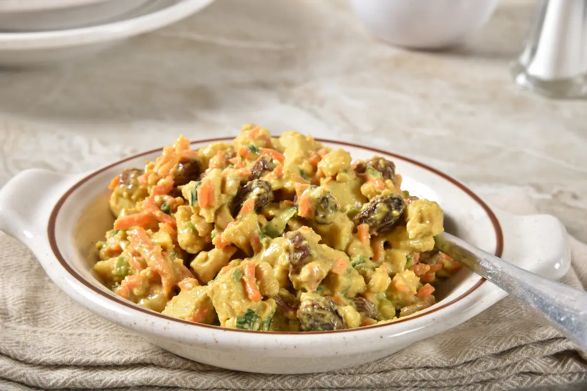 Bowl of creamy Hawaiian Macaroni Salad with shredded carrots and onions.