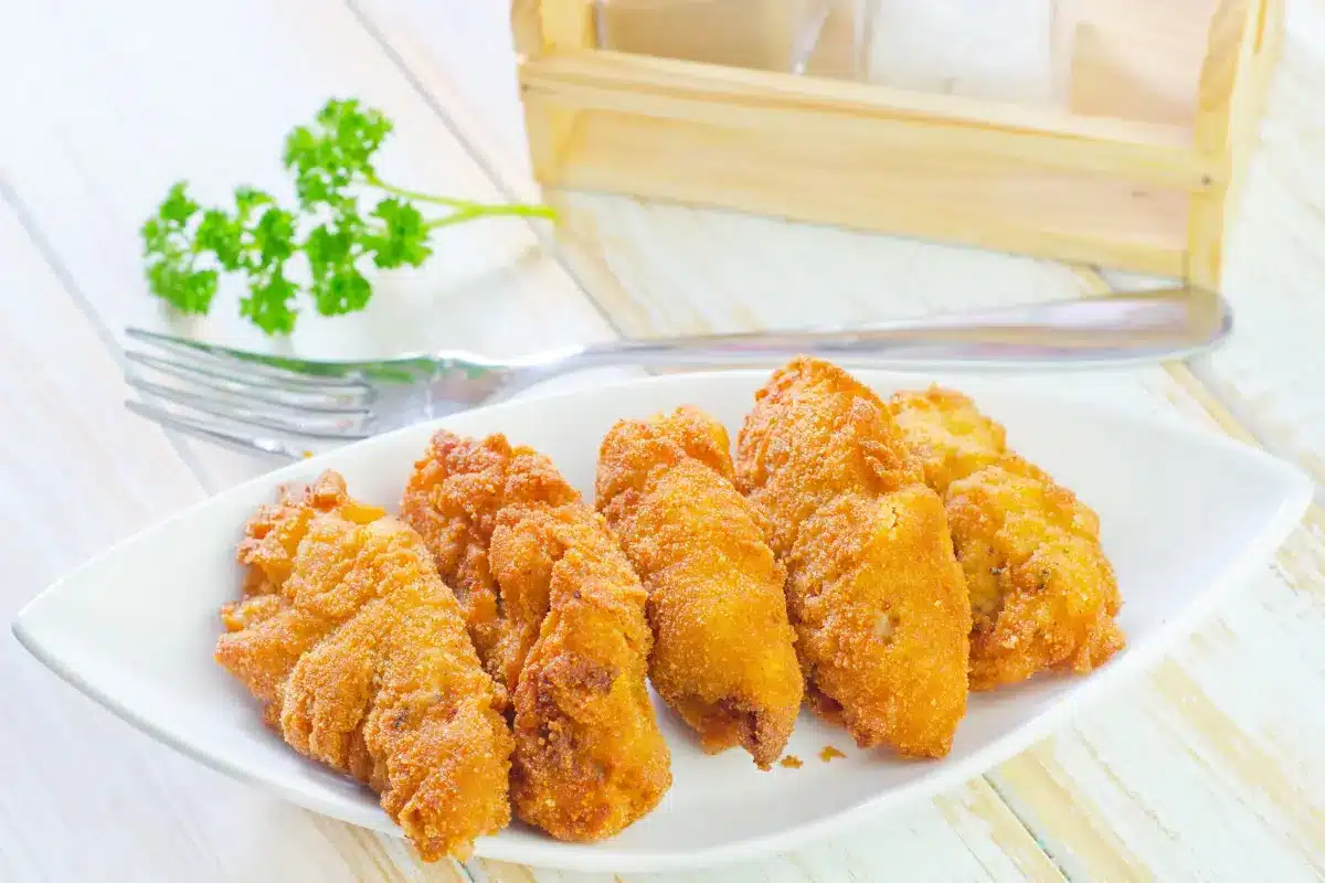 Golden-brown crispy corn nuggets with dipping sauce