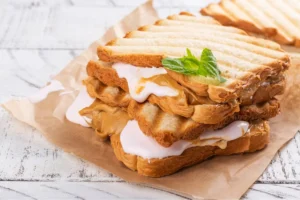 Three gourmet Fluffernutter sandwiches on a wooden board.