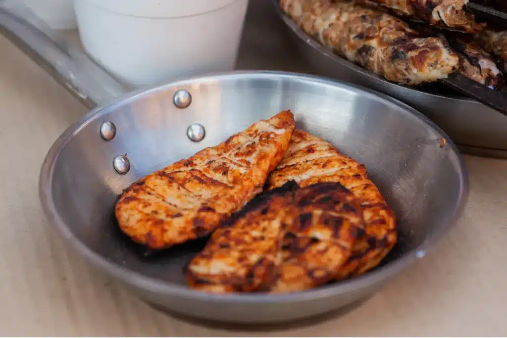 Juicy smoked chicken breast on a wooden cutting board with herbs