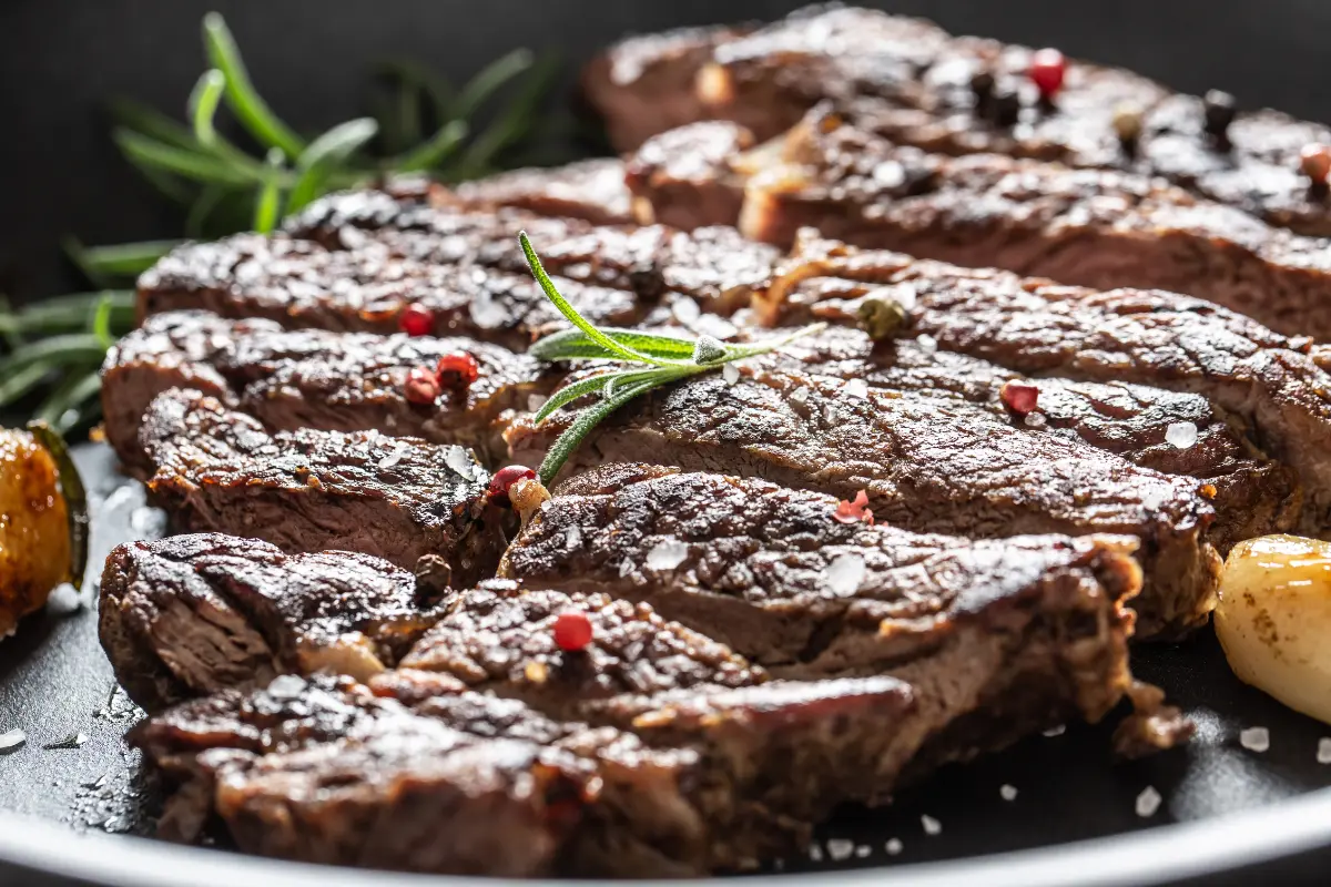 Succulent Steak Paillard with roasted vegetables and fresh herb garnish.