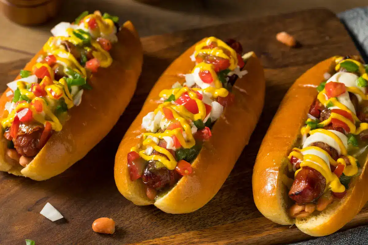 A fully loaded Sonoran hot dog with bacon, beans, and fresh toppings.