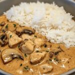 Creamy mushroom chicken and rice bowl in a white dish with sauce and mushrooms