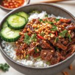 Shredded beef rice bowl with vegetables and herbs